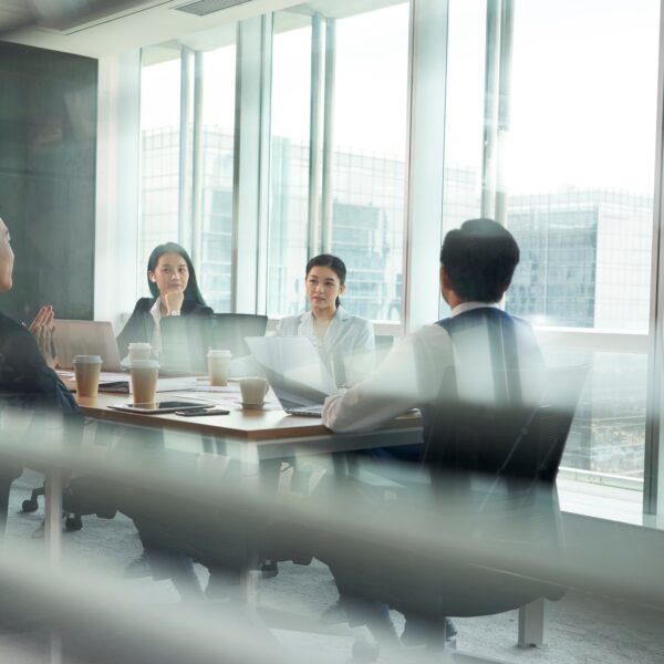 Group of people sitting at a conference table.