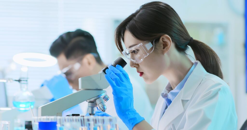 Scientist looking at microscope.