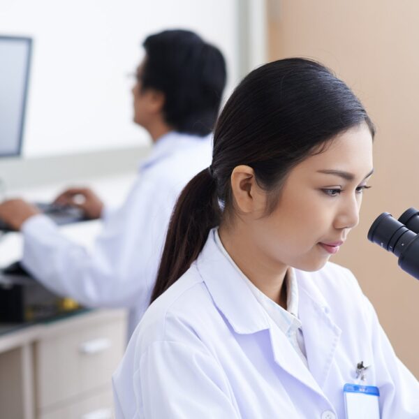 Lab worker looking in to a microscope.